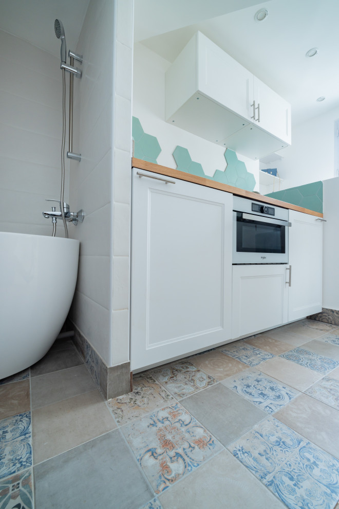 Idéer för ett litet nordiskt brun linjärt kök med öppen planlösning, med en undermonterad diskho, träbänkskiva, grönt stänkskydd, stänkskydd i keramik, vita vitvaror, cementgolv och blått golv