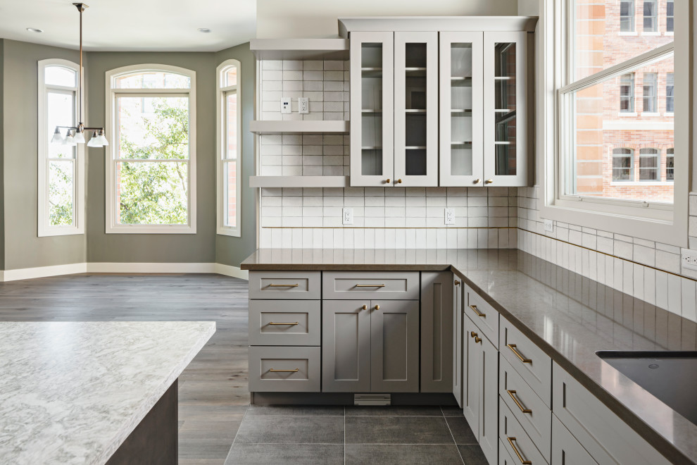 Large transitional galley ceramic tile and gray floor eat-in kitchen photo in Phoenix with an undermount sink, shaker cabinets, gray cabinets, quartz countertops, white backsplash, ceramic backsplash, stainless steel appliances, an island and gray countertops