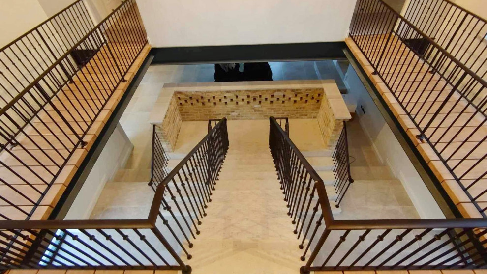 На фото: лестница на больцах, среднего размера в стиле модернизм с ступенями из травертина, подступенками из травертина и металлическими перилами