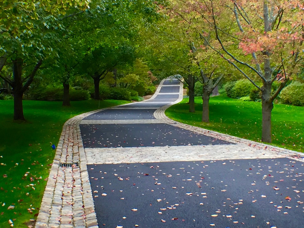 Design ideas for an expansive traditional front yard driveway in New York with natural stone pavers.
