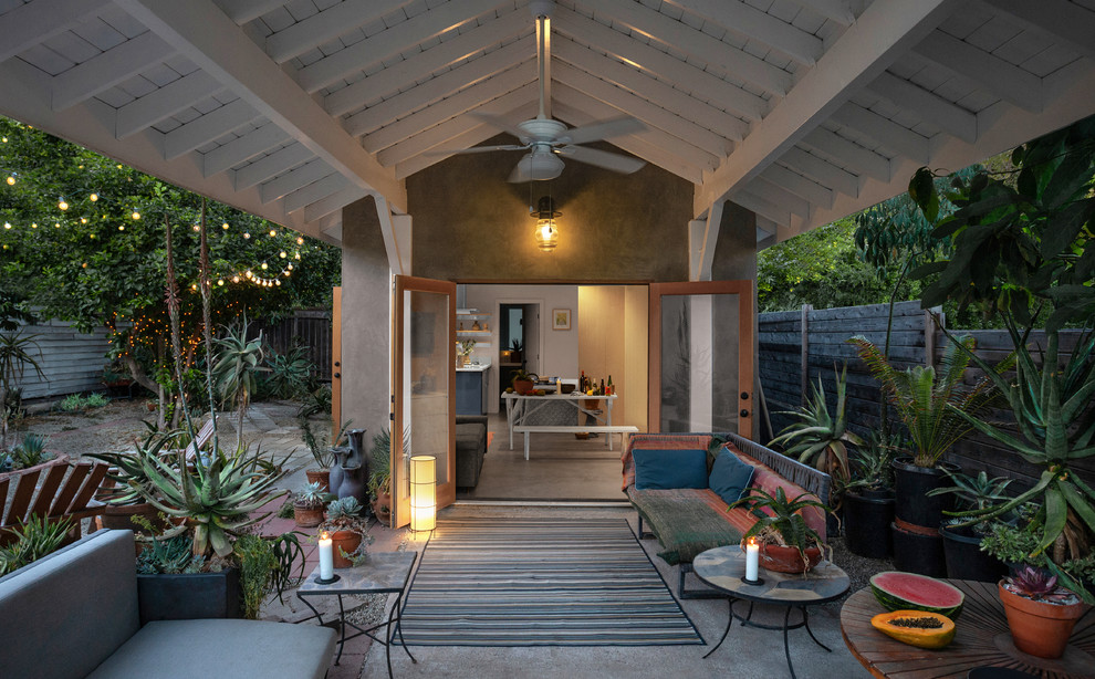 Photo of a small beach style backyard patio in Los Angeles with a container garden, concrete slab and a roof extension.