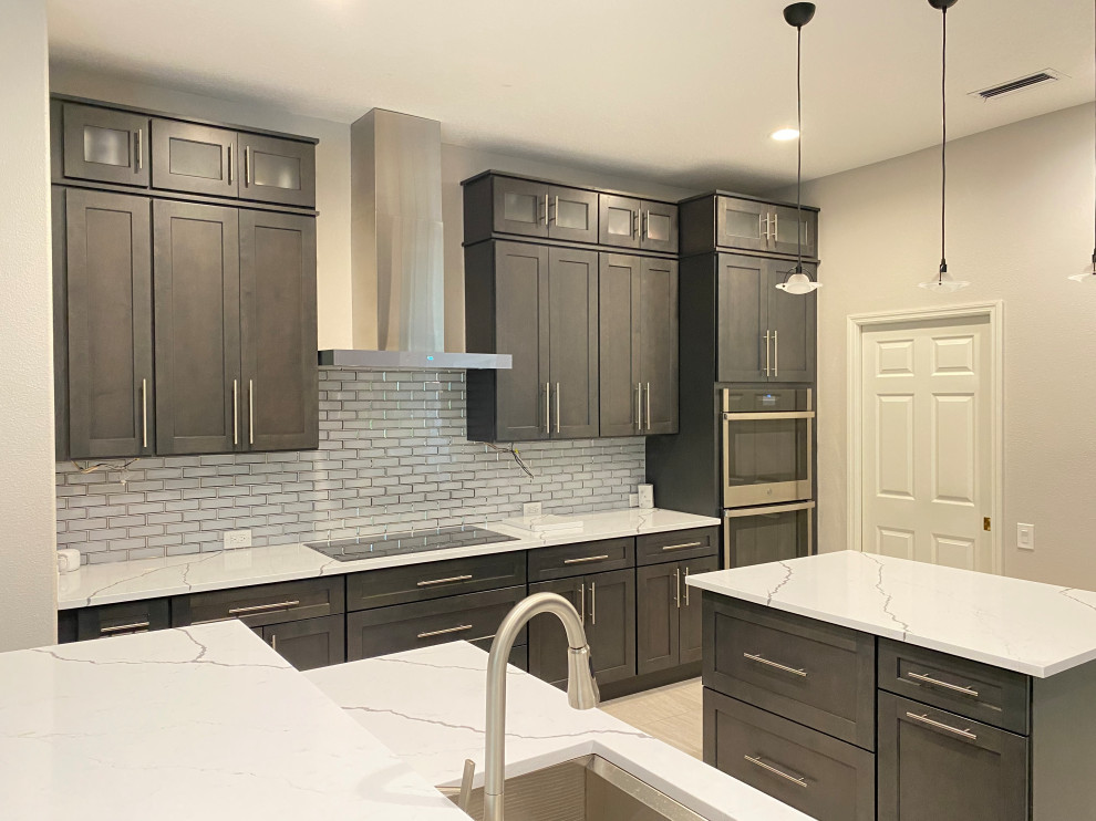 Example of a large transitional porcelain tile and beige floor eat-in kitchen design in Tampa with a single-bowl sink, shaker cabinets, dark wood cabinets, quartzite countertops, gray backsplash, subway tile backsplash, stainless steel appliances, an island and white countertops