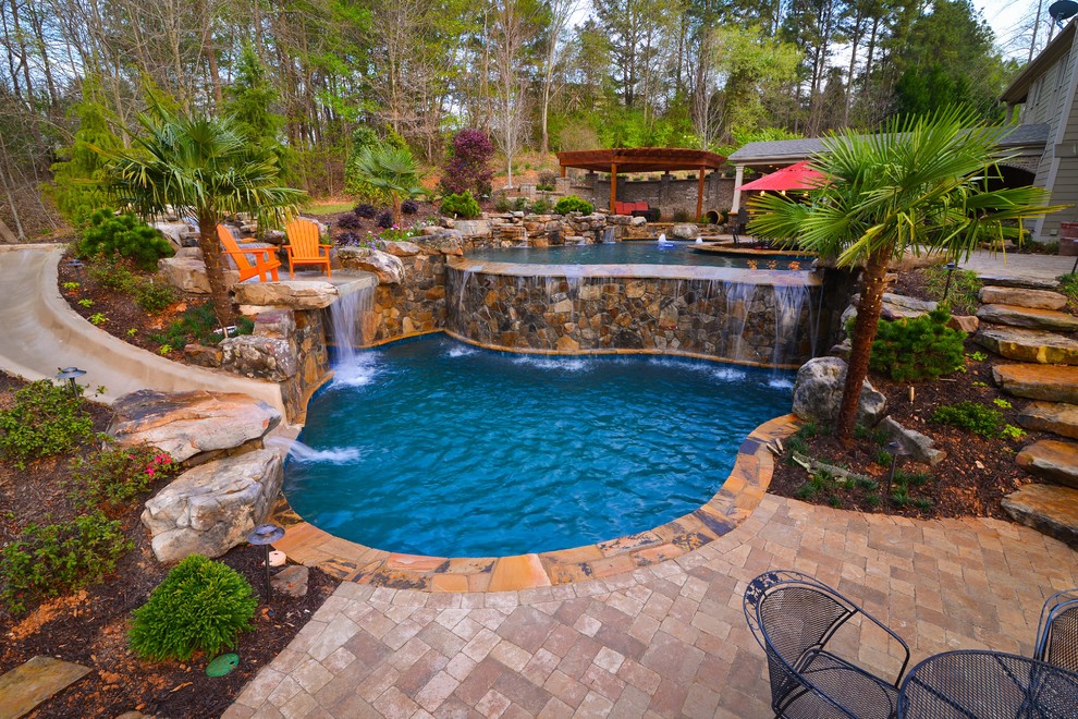 Design ideas for an expansive country backyard custom-shaped infinity pool in Atlanta with brick pavers.