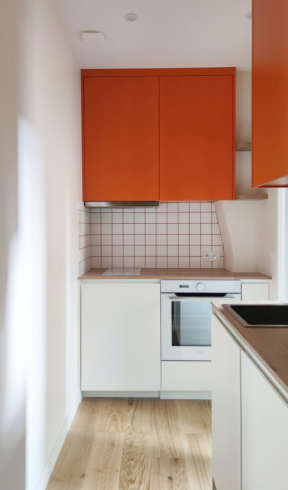 Exempel på ett mellanstort modernt brun linjärt brunt kök, med en enkel diskho, luckor med profilerade fronter, orange skåp, laminatbänkskiva, vitt stänkskydd, stänkskydd i keramik, vita vitvaror, ljust trägolv och flera köksöar