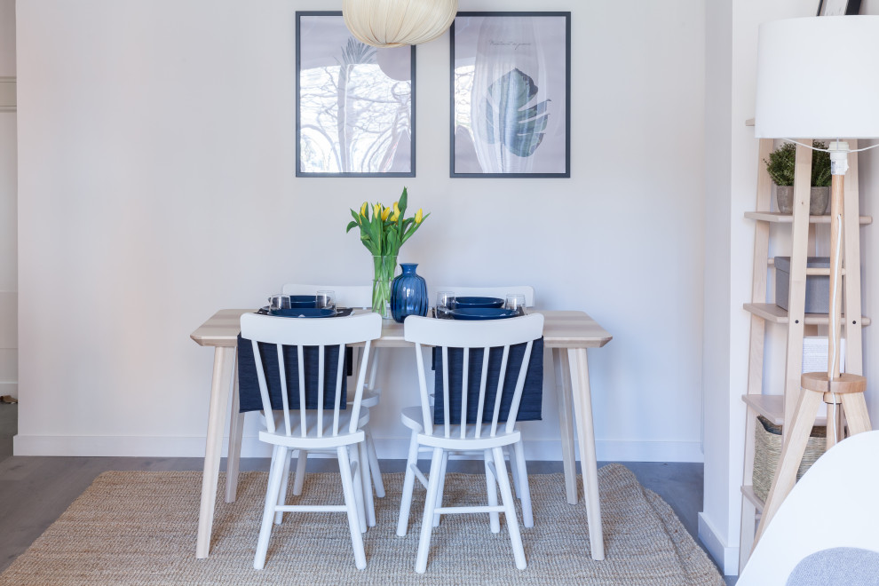 Ejemplo de comedor escandinavo de tamaño medio con paredes blancas, suelo laminado y suelo gris