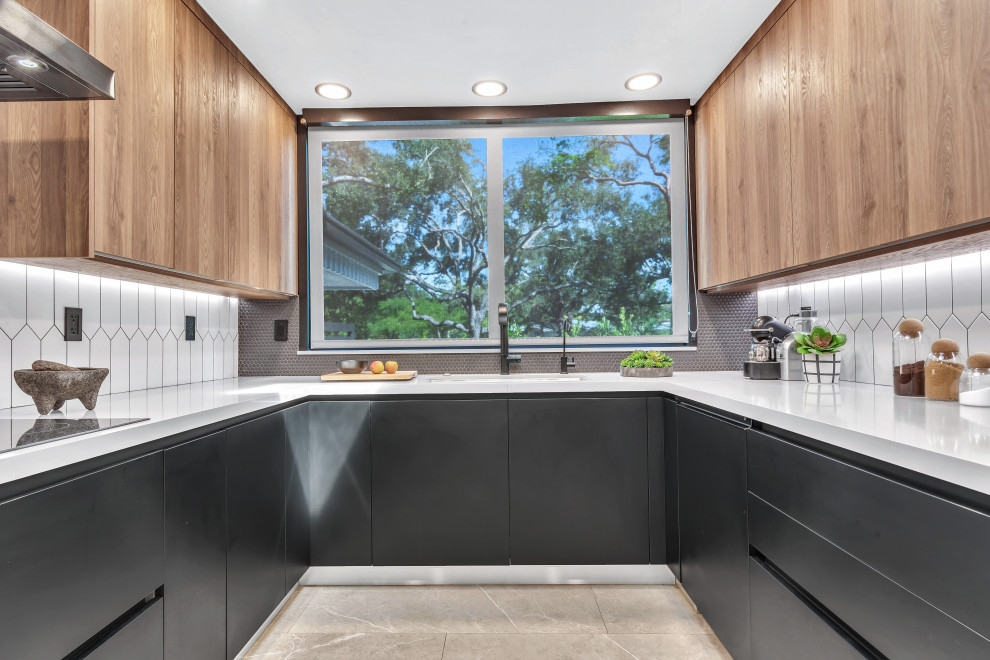 Inspiration for a medium sized midcentury u-shaped kitchen in Miami with a submerged sink, flat-panel cabinets, black cabinets, engineered stone countertops, white splashback, stone tiled splashback, integrated appliances, porcelain flooring, a breakfast bar, grey floors and grey worktops.