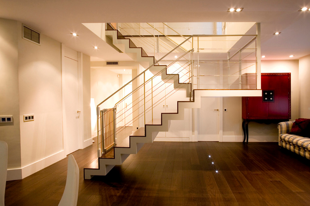 Large contemporary wood u-shaped staircase in Madrid with wood risers.