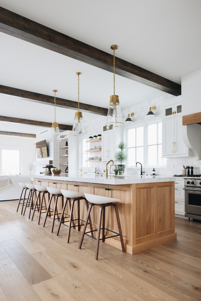 Kitchen - coastal l-shaped light wood floor and exposed beam kitchen idea in Grand Rapids with light wood cabinets, quartzite countertops, white backsplash, stainless steel appliances, an island and white countertops
