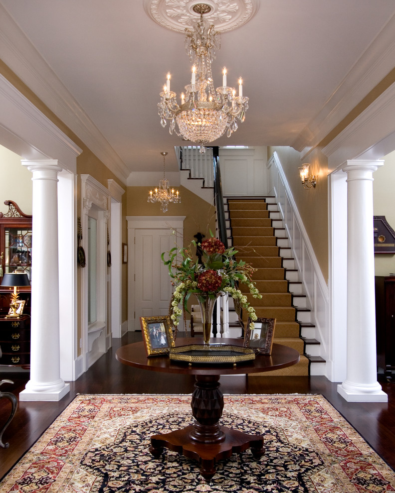 This is an example of a large traditional foyer in Orlando with yellow walls, dark hardwood floors and a single front door.