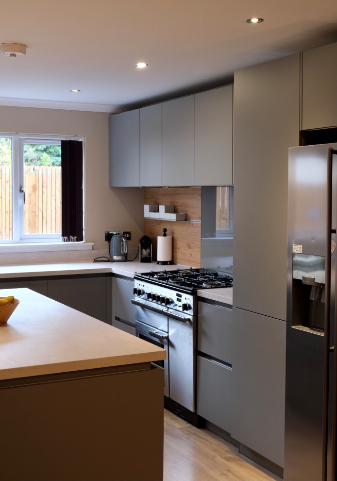 Cette image montre une cuisine ouverte grise et blanche minimaliste de taille moyenne avec une crédence grise, îlot et un plan de travail blanc.