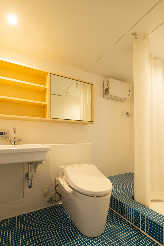 Immagine di un piccolo bagno di servizio minimal con WC monopezzo, pareti bianche, pavimento in gres porcellanato, lavabo sospeso, pavimento blu, soffitto in perlinato e pareti in perlinato