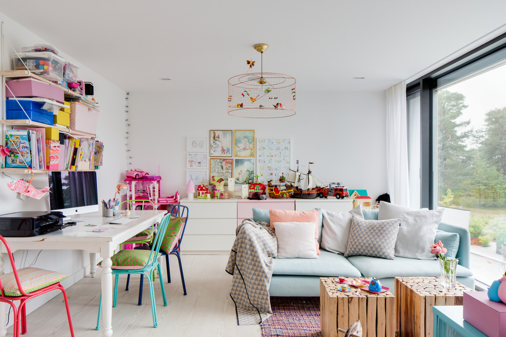 Contemporary gender-neutral kids' playroom in Malmo with white walls and light hardwood floors for kids 4-10 years old.