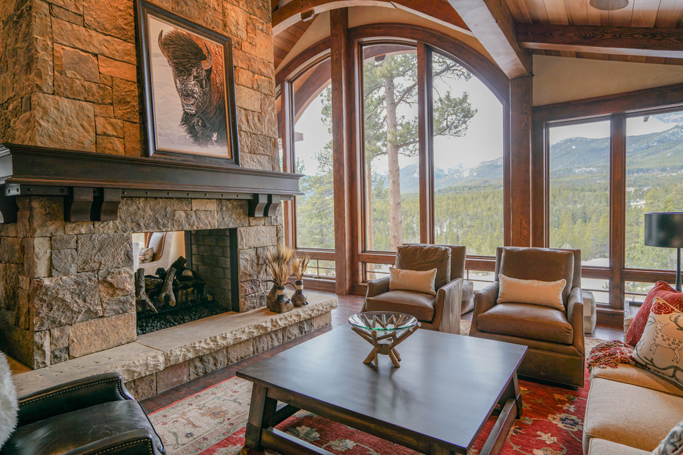 Inspiration for a large country open concept living room in Denver with beige walls, dark hardwood floors, a two-sided fireplace and a stone fireplace surround.