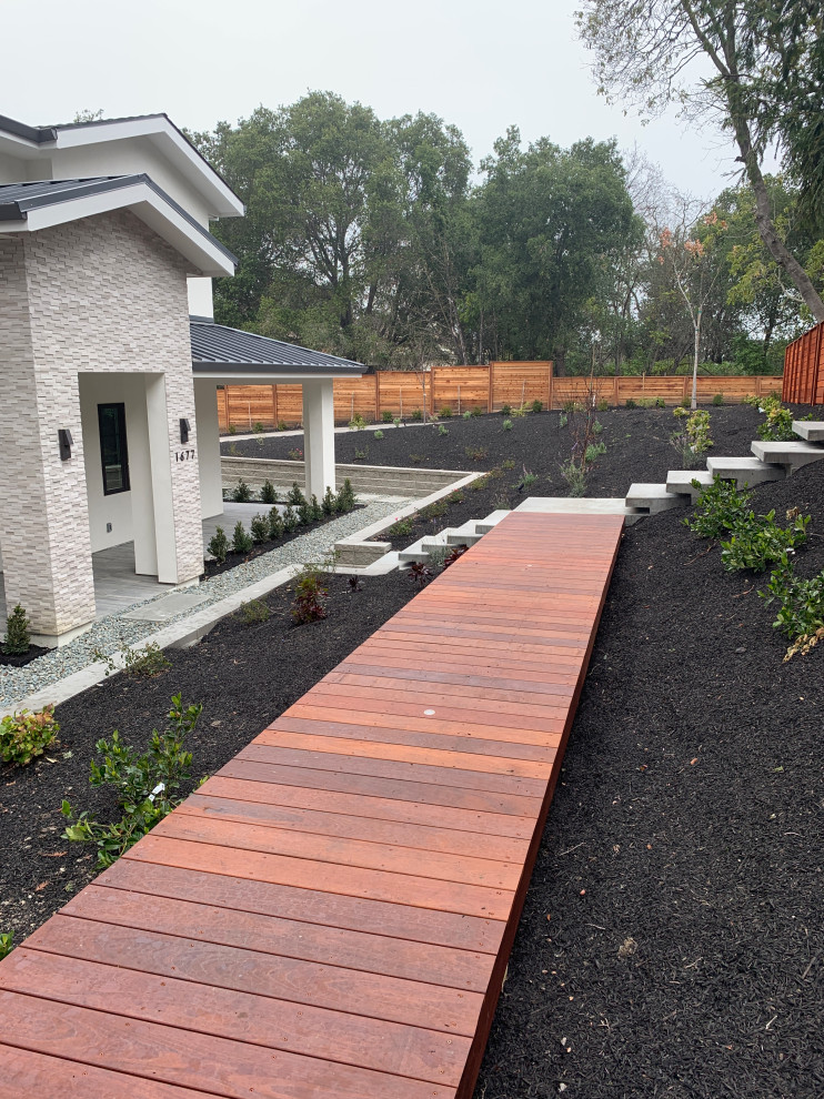 Photo of a large modern front yard full sun xeriscape for winter in San Francisco with with path and decking.