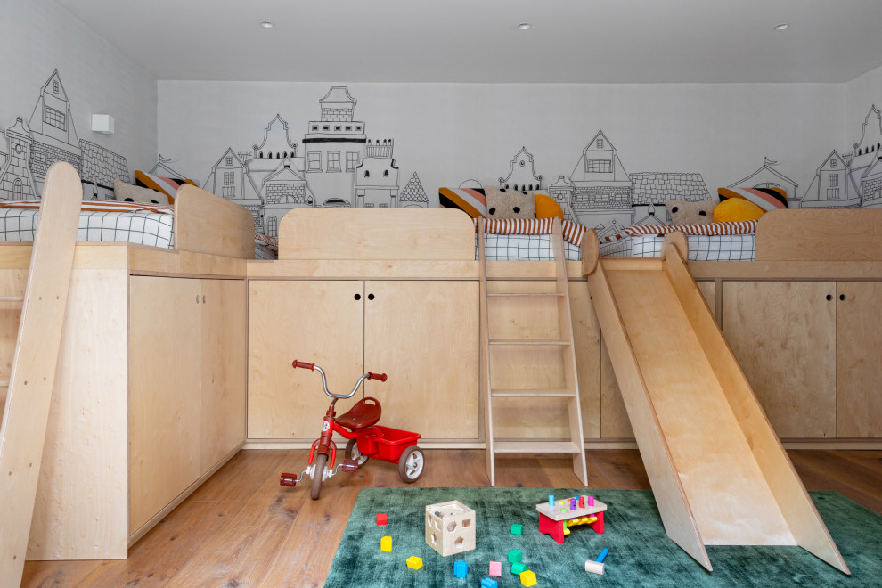 Immagine di una cameretta per bambini da 4 a 10 anni design di medie dimensioni con pareti bianche, parquet chiaro e carta da parati