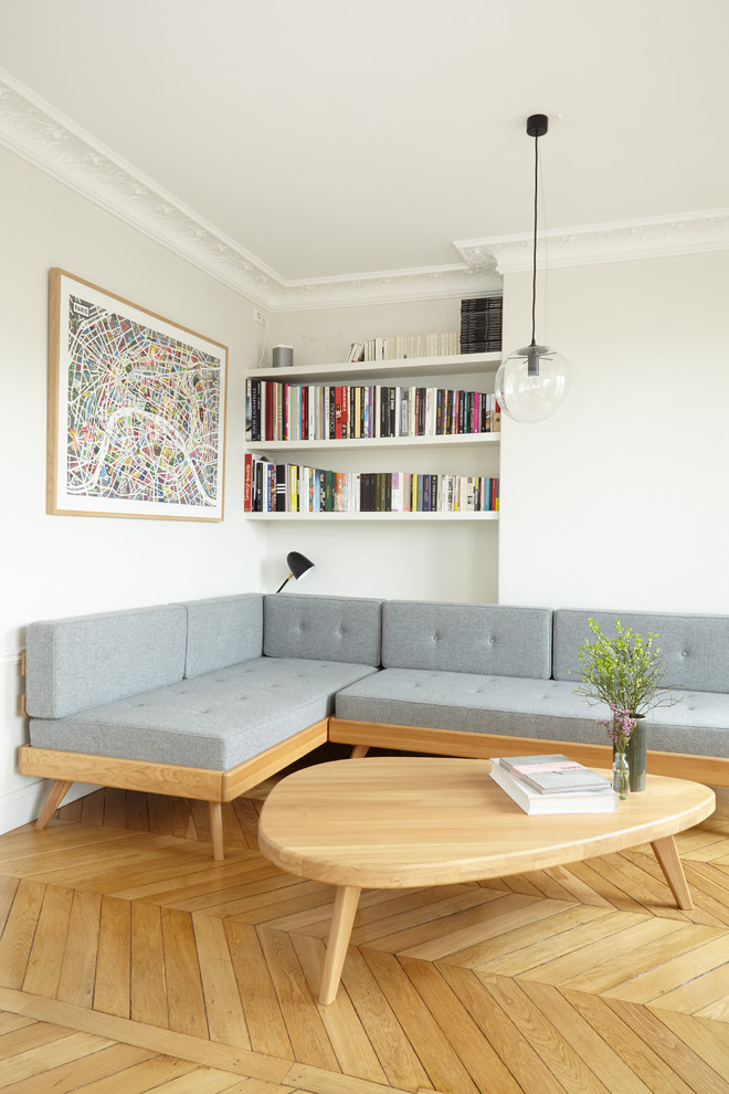 Modern living room in Paris with white walls, light hardwood floors and beige floor.