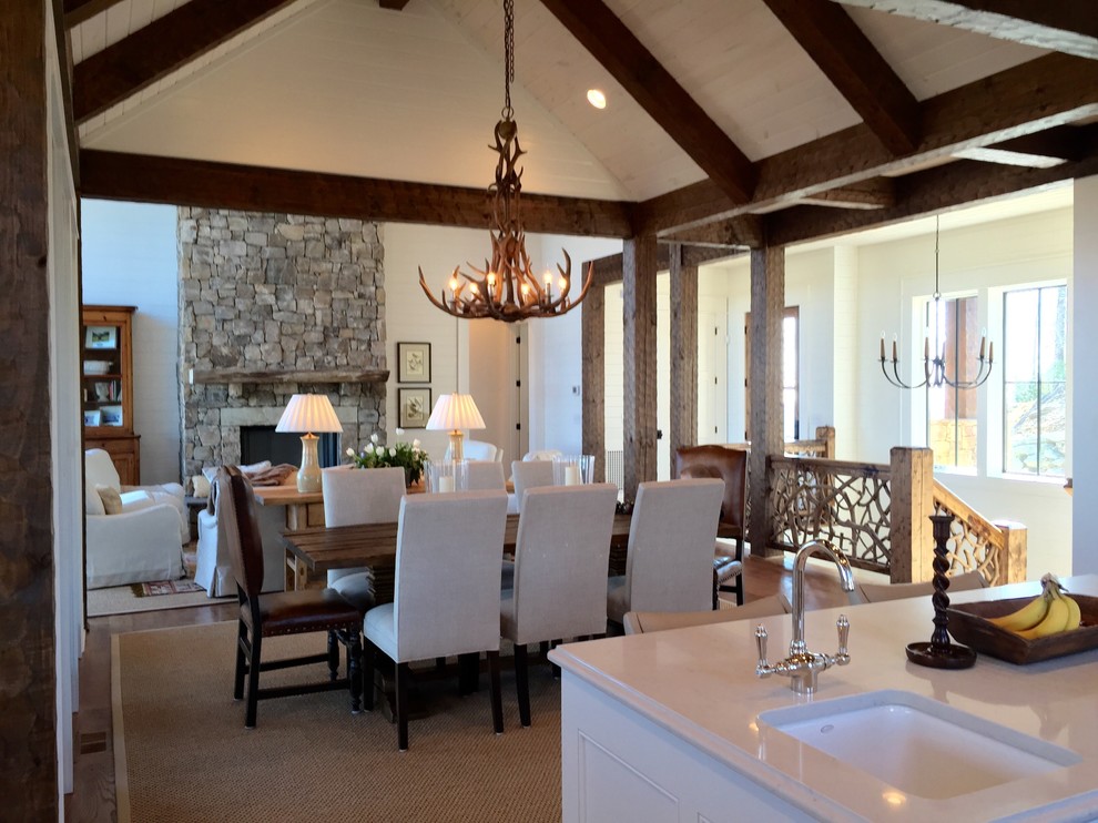 Esempio di una sala da pranzo stile rurale con pareti bianche, pavimento in legno massello medio, camino classico e cornice del camino in pietra