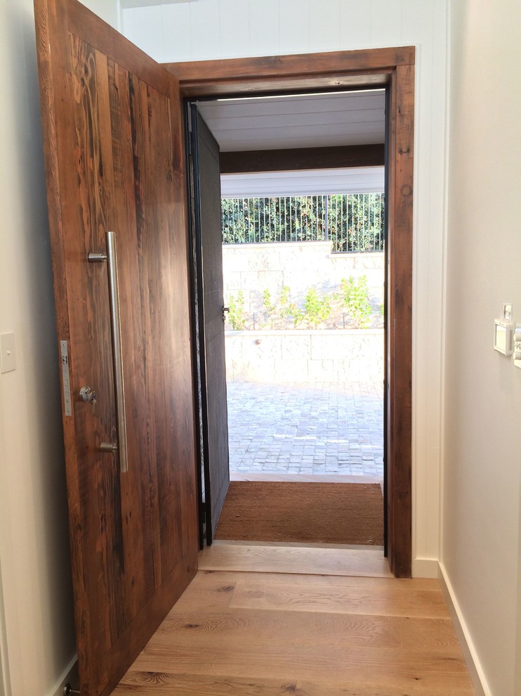 Inspiration for a mid-sized beach style front door in Sydney with white walls, light hardwood floors, a single front door and a dark wood front door.
