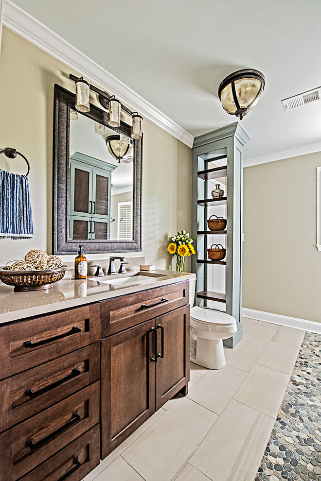 Large eclectic 3/4 bathroom in Nashville with raised-panel cabinets, brown cabinets, an alcove tub, a shower/bathtub combo, a one-piece toilet, white tile, subway tile, beige walls, pebble tile floors, an undermount sink, multi-coloured floor, a shower curtain, beige benchtops and engineered quartz benchtops.