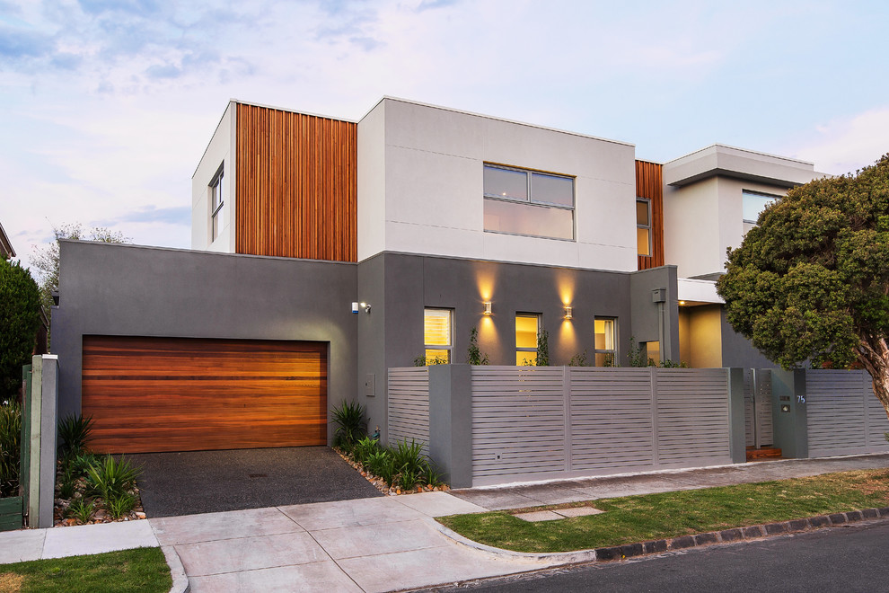 Design ideas for a contemporary two-storey exterior in Melbourne with mixed siding and a flat roof.
