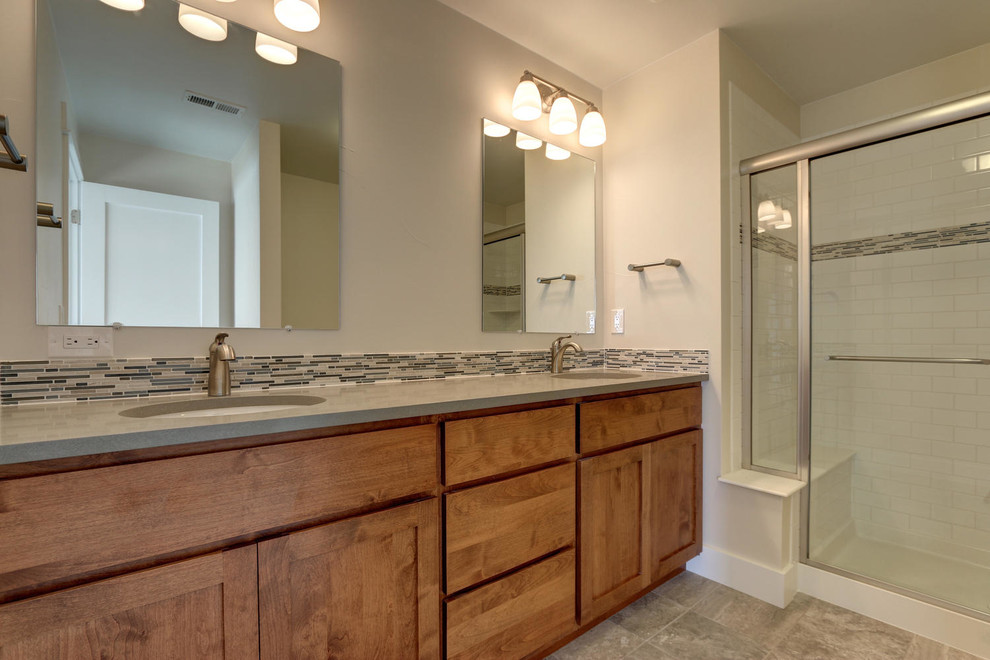 Large arts and crafts 3/4 bathroom in Denver with flat-panel cabinets, medium wood cabinets, an alcove shower, a two-piece toilet, beige tile, black and white tile, white tile, subway tile, beige walls, porcelain floors, an undermount sink and solid surface benchtops.