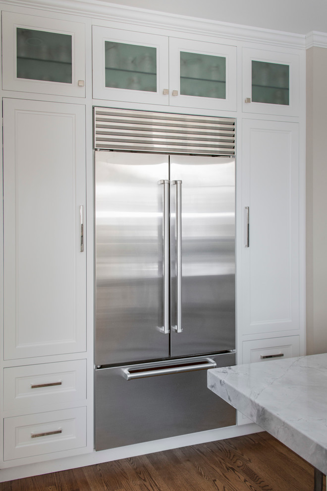Eat-in kitchen - mid-sized transitional l-shaped dark wood floor eat-in kitchen idea in Chicago with an undermount sink, recessed-panel cabinets, white cabinets, quartzite countertops, white backsplash, glass tile backsplash, stainless steel appliances and an island