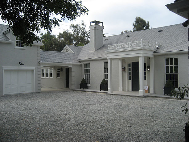 Large transitional two-storey brick grey exterior in Los Angeles with a gable roof.