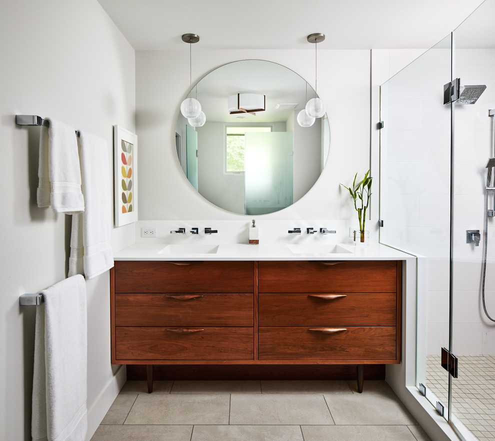 Inspiration for a large midcentury master bathroom in DC Metro with medium wood cabinets, ceramic floors, solid surface benchtops, grey floor, a hinged shower door, white benchtops, an alcove shower, white tile, grey walls, an integrated sink and flat-panel cabinets.