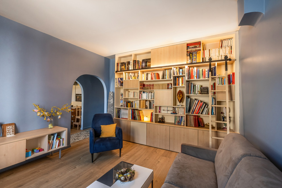 Idee per un grande soggiorno contemporaneo chiuso con libreria, pareti blu, pavimento in legno massello medio e pavimento marrone