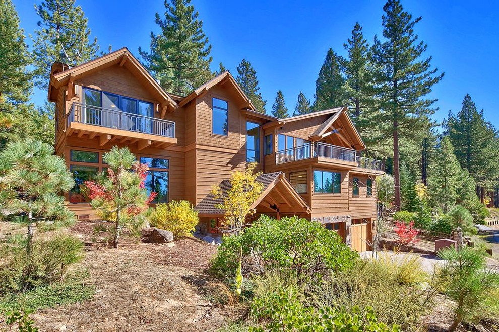 Large transitional brown three-story mixed siding gable roof photo with a shingle roof