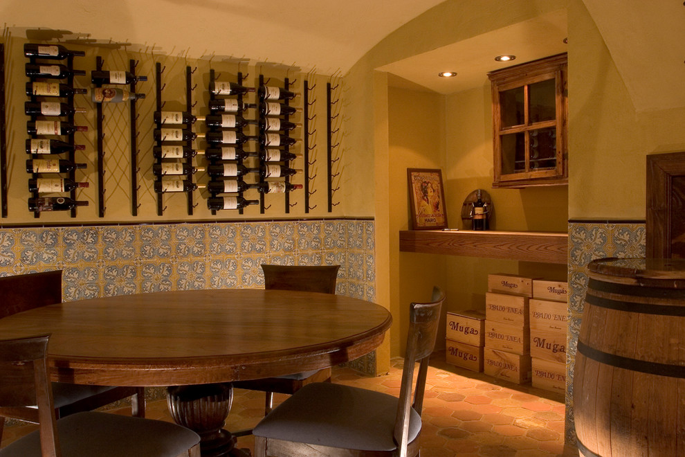 Inspiration for a mediterranean wine cellar in Charlotte with terra-cotta floors, display racks and orange floor.