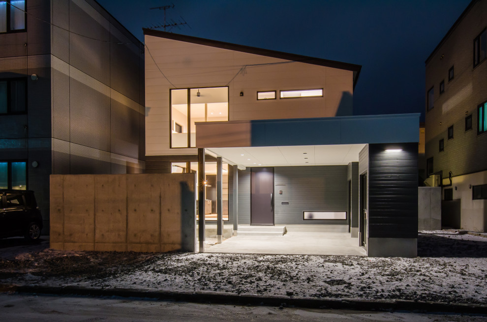 Свежая идея для дизайна: двухэтажный, серый частный загородный дом среднего размера в восточном стиле с облицовкой из металла, односкатной крышей, металлической крышей и черной крышей - отличное фото интерьера