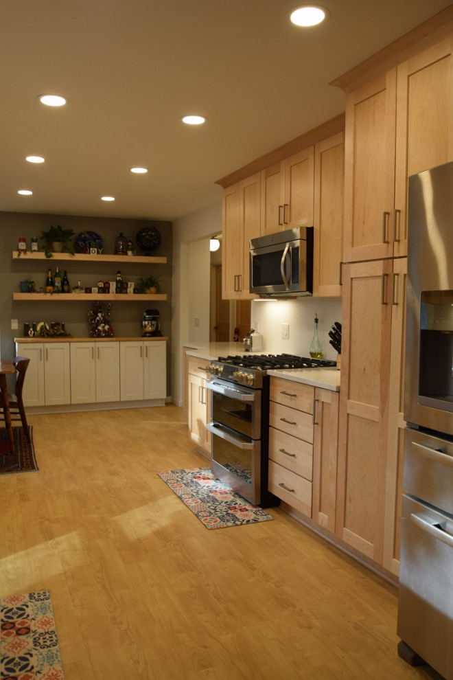 Inspiration for a galley vinyl floor kitchen remodel with an undermount sink, shaker cabinets, light wood cabinets, quartz countertops, stainless steel appliances and white countertops