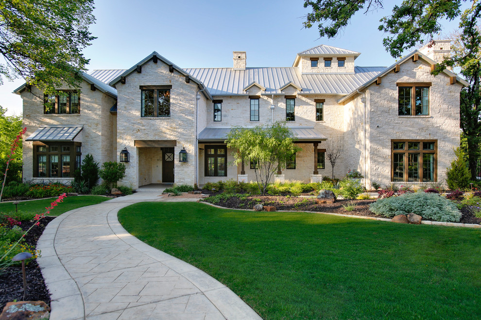 Inspiration for a transitional two-storey beige exterior in Dallas with stone veneer and a gable roof.