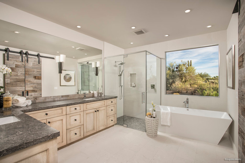 Photo of a mid-sized contemporary master bathroom in Phoenix with light wood cabinets, a freestanding tub, white tile, porcelain tile, white walls, porcelain floors, an undermount sink and marble benchtops.
