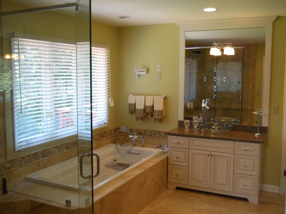 This is an example of a large contemporary master bathroom in Other with a vessel sink, a drop-in tub, a corner shower, white cabinets, granite benchtops, beige tile, stone tile, green walls and travertine floors.