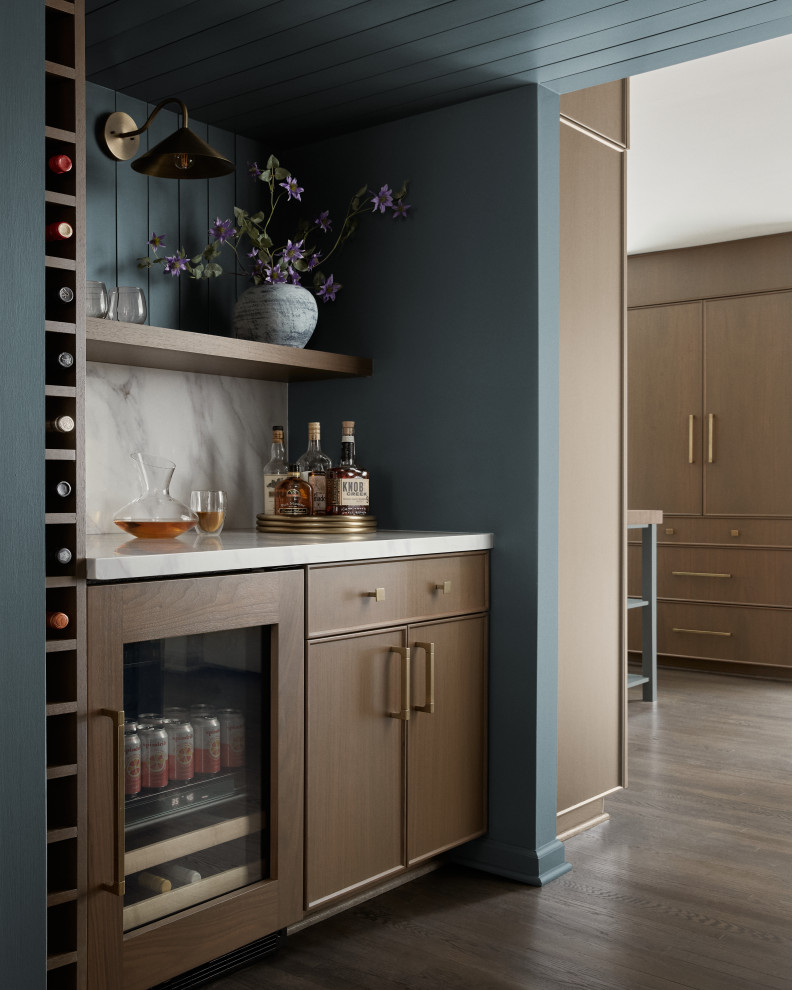 Inspiration for a small transitional single-wall dark wood floor and brown floor dry bar remodel in DC Metro with flat-panel cabinets, medium tone wood cabinets, quartz countertops, white backsplash, quartz backsplash and white countertops