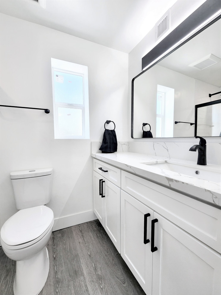 Photo of a small scandinavian 3/4 bathroom in Phoenix with beaded inset cabinets, white cabinets, a drop-in tub, an open shower, a one-piece toilet, white tile, ceramic tile, white walls, vinyl floors, a drop-in sink, marble benchtops, beige floor, an open shower, white benchtops, an enclosed toilet, a single vanity, a floating vanity and vaulted.