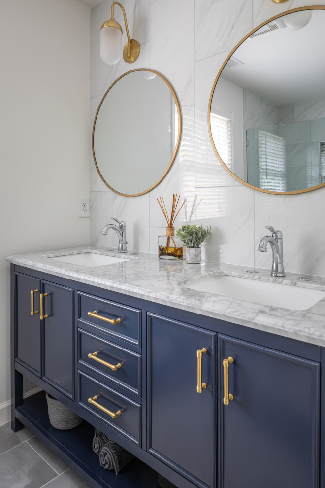 This is an example of a small transitional master bathroom in Raleigh with furniture-like cabinets, white walls, porcelain floors, a vessel sink, quartzite benchtops, grey floor, white benchtops, blue cabinets, a shower/bathtub combo, white tile, marble and a hinged shower door.