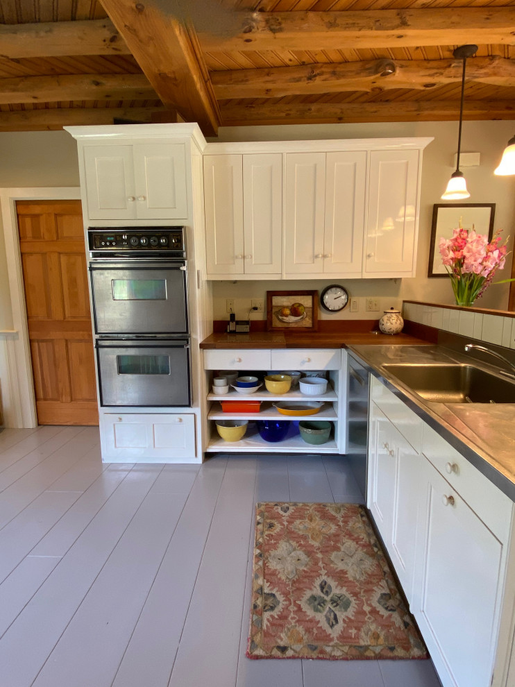 Eat-in kitchen - large traditional painted wood floor, gray floor and exposed beam eat-in kitchen idea in Boston with a single-bowl sink, shaker cabinets, yellow cabinets, wood countertops, stainless steel appliances, no island and brown countertops