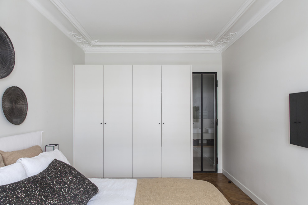 Mid-sized scandinavian master bedroom in Paris with grey walls, medium hardwood floors, no fireplace and brown floor.