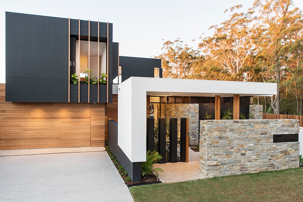 Inspiration for a contemporary split-level exterior in Brisbane with mixed siding and a flat roof.