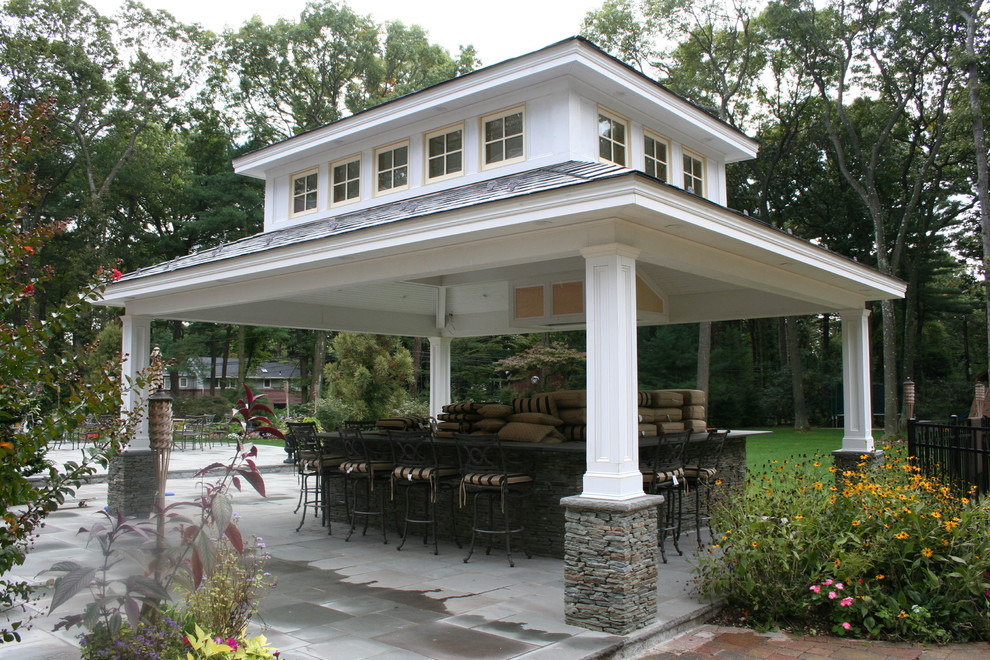 Design ideas for a beach style backyard patio in New York with natural stone pavers and a gazebo/cabana.