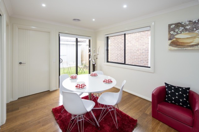 This is an example of a small contemporary kitchen/dining combo in Melbourne with white walls and bamboo floors.