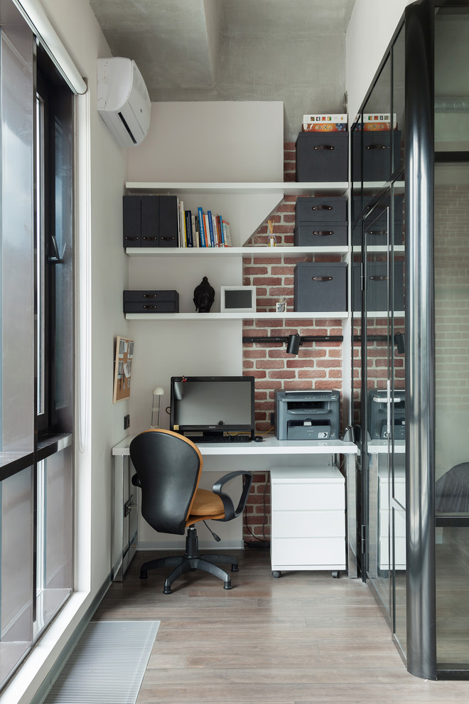 Small industrial study room in Moscow with a freestanding desk, multi-coloured walls and medium hardwood floors.