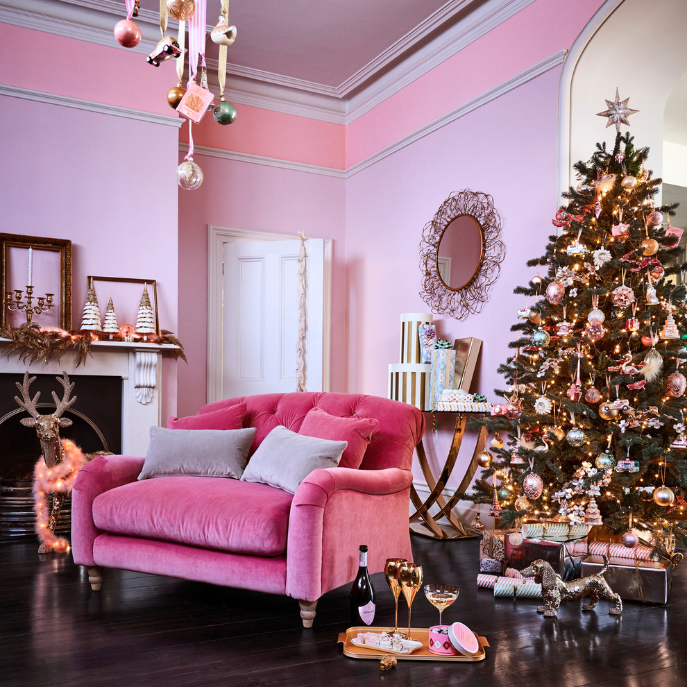 Inspiration for a traditional living room in London with pink walls, dark hardwood floors and a standard fireplace.