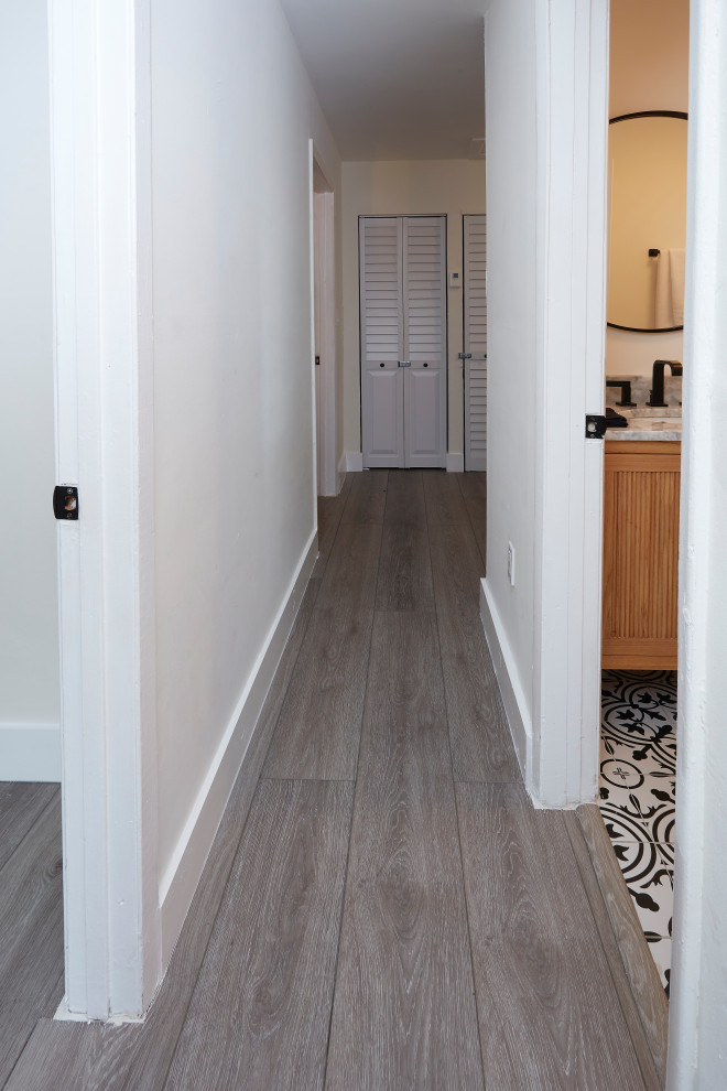 Exemple d'un petit couloir éclectique avec un mur blanc, un sol en vinyl et un sol gris.
