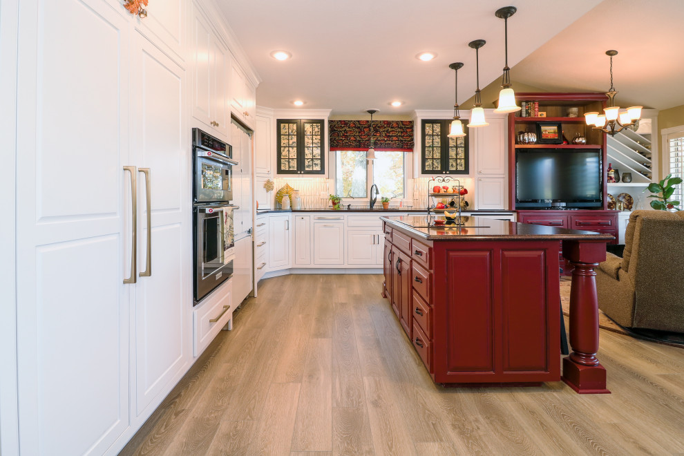 Mid-sized transitional l-shaped vinyl floor and beige floor eat-in kitchen photo with an undermount sink, shaker cabinets, white cabinets, granite countertops, white backsplash, ceramic backsplash, stainless steel appliances, an island and black countertops