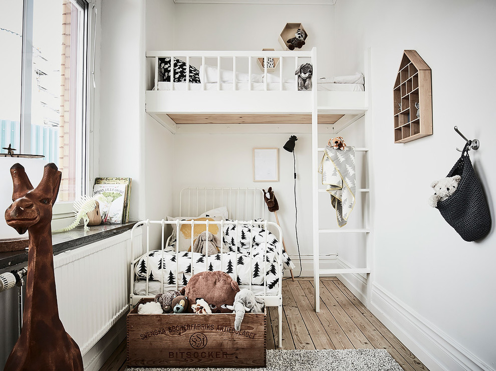 Design ideas for a small traditional gender-neutral kids' bedroom for kids 4-10 years old in Gothenburg with beige walls and light hardwood floors.