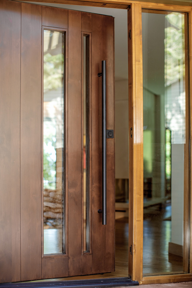 На фото: большая входная дверь в стиле ретро с бетонным полом, одностворчатой входной дверью, входной дверью из темного дерева и коричневым полом с